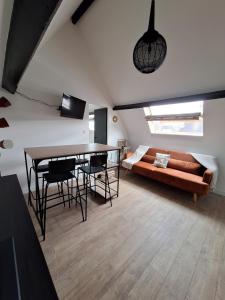 een woonkamer met een bank en een tafel bij A 2 pas de la plage in Le Portel