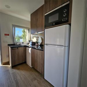 a kitchen with a white refrigerator and a microwave at Marinha Grande Apartamentos Rainbow N9 in Marinha Grande