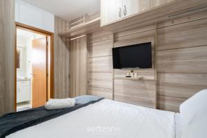 Un dormitorio con una cama y un televisor de pantalla plana. en Apto de 1 dormitorio a 850 m del MASC - CFE0503, en Florianópolis