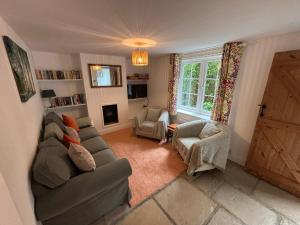 a living room with a couch and chairs and a door at Delightful 3-bedroom Cottage, Brockenhurst in Brockenhurst