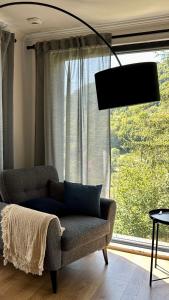 a living room with a couch and a large window at Cabana207 - Private Mountain Cabin with Hot Tub in Bulz