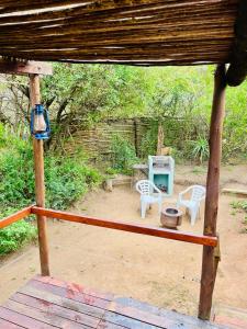 un porche con 2 sillas y una mesa en Firefly Farm, en KwaNibela 37 fotos más