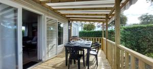 un porche con mesa y sillas en Salsa confort, en Les Mathes