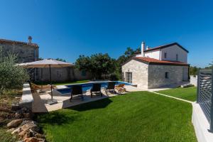 a backyard with a swimming pool and a house at Villa Nina with private pool and BBQ near Poreč in Bonaci