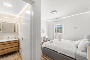 a white bedroom with a bed and a sink at Villa Nina with private pool and BBQ near Poreč in Bonaci +26 photos