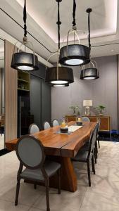a dining room with a wooden table and chairs at Luxury Apartemen Anderson Benson PTC By Staycation in Surabaya