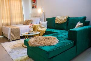a living room with a green couch and a table at Yemane luxury Studio in Mombasa