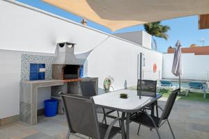een eetkamer met een tafel en een open haard bij Casa Azul in Conil de la Frontera