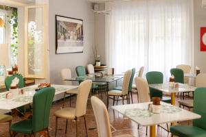 a dining room with tables and chairs and a window at Aparthotel Manolita in Rimini