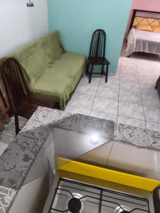 a kitchen with a stove and a couch in a room at Canto da paz in Praia Grande +3 photos