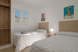 een slaapkamer met twee bedden en een raam bij Casa Azul in Conil de la Frontera +20 foto's