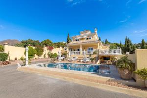 Una casa grande con piscina delante de ella. en Charming One-Bedroom Flat Dormitory room, en Estepona