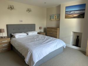 a bedroom with a large bed and a fireplace at Kurnell Cottage, Staithes in Staithes