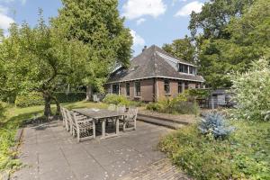a patio with a table and chairs in front of a house at Boerderijwoning 't Boetje in Heiloo