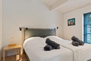 a bedroom with a bed with black pillows on it at Boerderijwoning 't Boetje in Heiloo