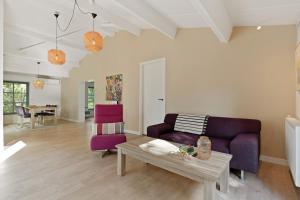 a living room with a purple couch and a table at Boerderijwoning 't Boetje in Heiloo