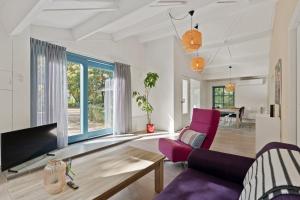 a living room with a purple couch and a table at Boerderijwoning 't Boetje in Heiloo