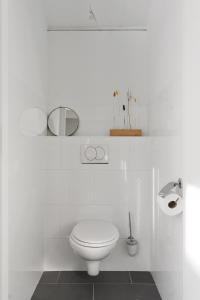a white bathroom with a toilet and a mirror at Boerderijwoning 't Boetje in Heiloo +20 photos