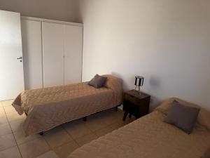 a bedroom with two beds and a dresser and a bedskirts at Ricon de malvones vintage in General Alvear
