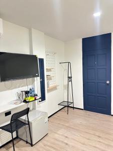 a room with a blue door and a desk with a chair at Jellyfish Residence in Patong Beach