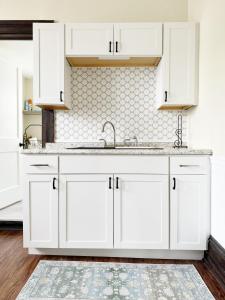 a kitchen with white cabinets and a sink at Chandler Studio Apartments in Evansville