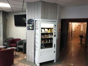 a white refrigerator in a room with drinks at L'Hôtel du Marais Romilly Centre in Romilly-sur-Seine