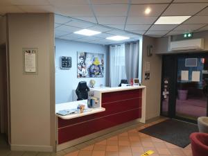 an office with a reception desk in a room at L'Hôtel du Marais Romilly Centre in Romilly-sur-Seine