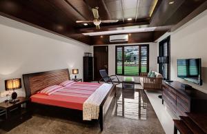 1 dormitorio con 1 cama grande y TV en Chacha Villa, en Ābu Road
