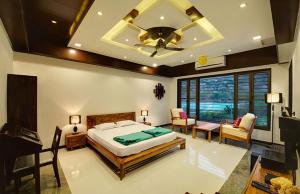 1 dormitorio con 1 cama y ventilador de techo en Chacha Villa, en Ābu Road