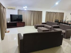 un salon avec des canapés et une télévision à écran plat dans l'établissement Large 4 Bedroom 5 Bed Villa in Sonaisali Rd, Nadi, à Nadi