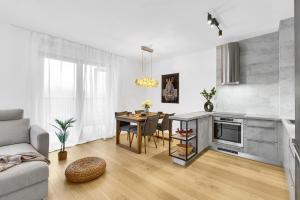Una sala de estar con una mesa y una cocina. en BNB Guthaus Retreat with balcony, en Koliba