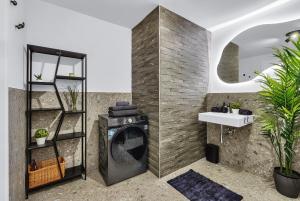 Un baño con lavadora y lavabo. en BNB Guthaus Retreat with balcony, en Koliba 49 fotos más