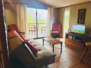 Una sala de estar con un sofá, un televisor y una mesa. en Firefly Farm, en KwaNibela