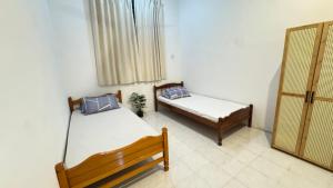a bedroom with two beds and a window at Home Stay Lembah Bujang in Bedung