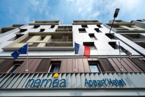 Un edificio con banderas en el costado. en Nemea Appart Hotel Quai Victor Tours Centre, en Tours