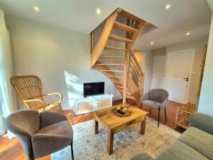 a living room with a staircase and two chairs at Maison La Côtière proche plage avec parking in Camiers +30 photos
