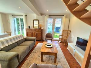 a living room with a couch and a coffee table at Maison La Côtière proche plage avec parking in Camiers