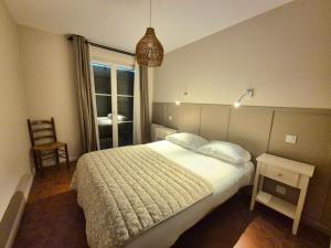 a bedroom with a bed and a chair and a window at Maison La Côtière proche plage avec parking in Camiers