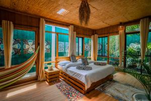 a bedroom with a bed in a room with windows at Mango Eco Cabin by Banana Farm in Nkoanrua +31 photos