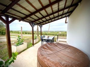 a bedroom with a bed and a table on a patio at BorászPorta KisHáz in Villány