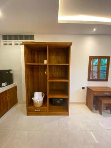 a wooden book shelf in a room with a table at Malaka pedati homestay in Bingin Beach