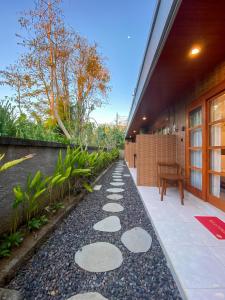 a walkway outside of a building with a bench at Malaka pedati homestay in Bingin Beach