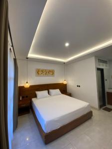 a bedroom with a large white bed in it at Malaka pedati homestay in Bingin Beach