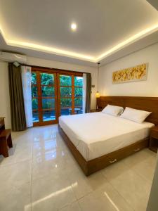 a bedroom with a large bed and a large window at Malaka pedati homestay in Bingin Beach +7 photos