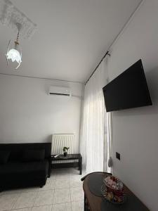 a living room with a couch and a table at Le Bel Appartement D'Antigoni in Alexandroupoli