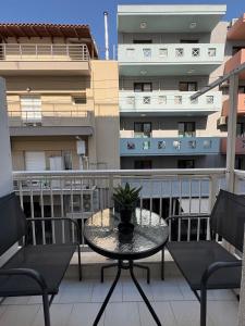 a patio with a table and chairs on a balcony at Le Bel Appartement D'Antigoni in Alexandroupoli