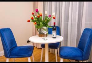 a table with a bottle of wine and a vase of flowers at ORBI CITY Luxe Suites Hotel in Batumi