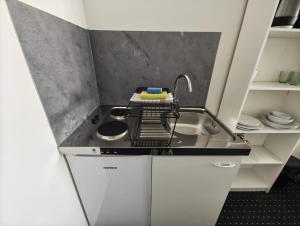 a small kitchen with a sink and a faucet at Serviced Apartments Augsburg Lechhausen in Augsburg +8 photos
