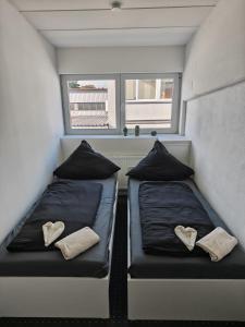 two beds in a small room with a window at Serviced Apartments Augsburg Lechhausen in Augsburg