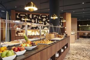 a buffet line with fruits and pastries on display at NH Frankfurt Airport in Kelsterbach
